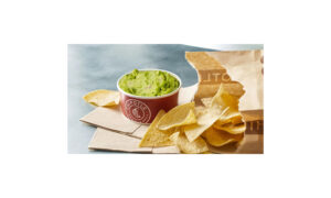A Chipotle-branded cup of guacamole with tortilla chips